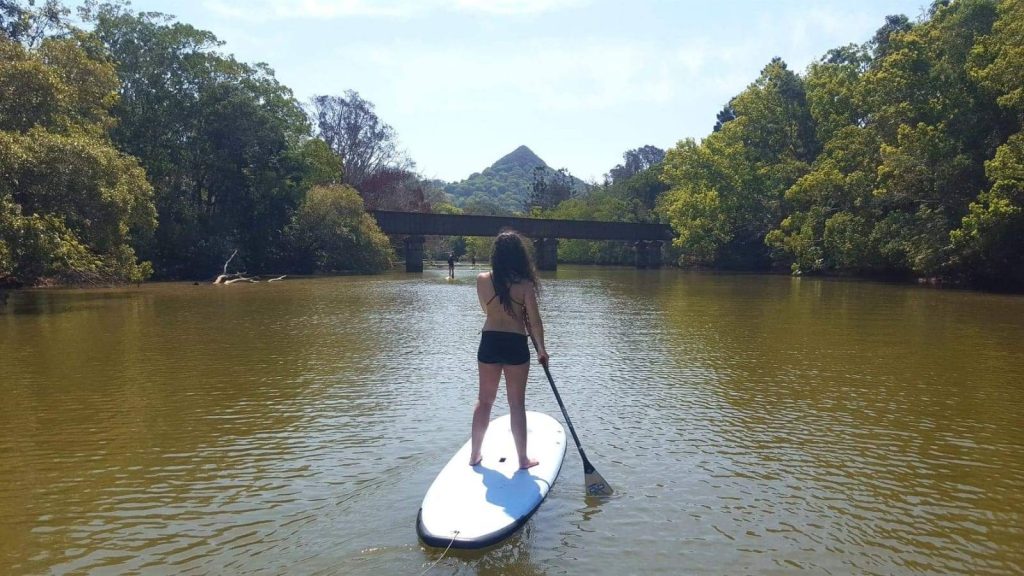 Cristina Calero stand-up paddle boarding on the Brunswick River, Mt Chincogan in the distance.