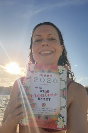 Cristina Calero on the beach with her 2026 DIARY for the wild, creative heart
